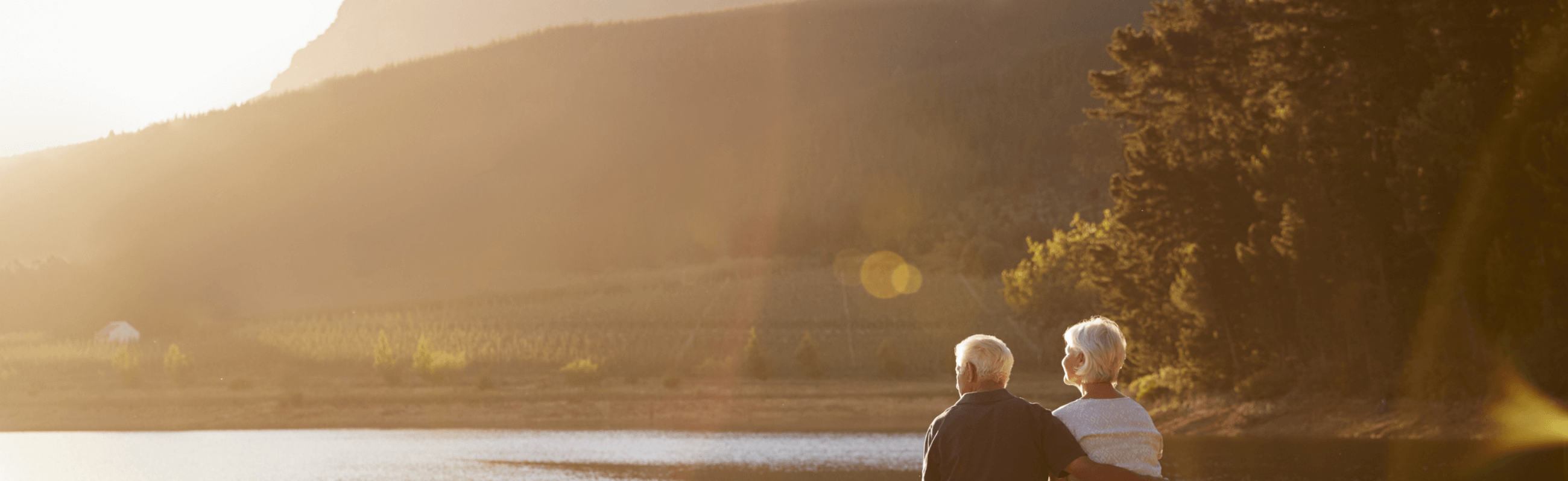 Photograph of a couple enjoying a sunset over a lake